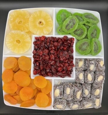 Dried fruit platter of pineapple rings, kiwi, cranberries, apricots, and date coconut rolls